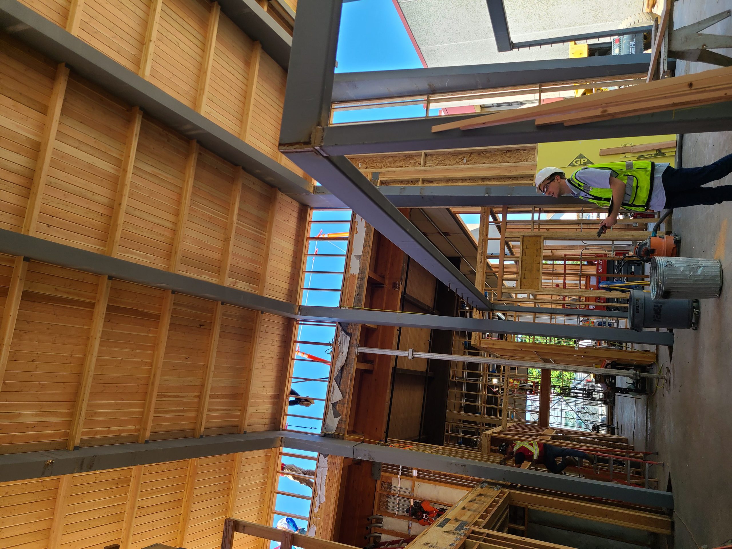 Scott Schroeder looks up at the bent steel frames that will make up the main corridor and team room area at Olympic College Shops.